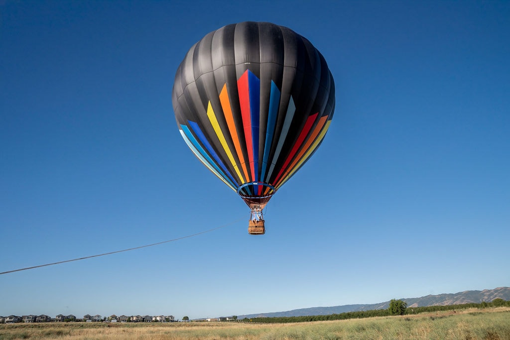 Uplift Ballooning balloon tethered low over open fields near Winters, California